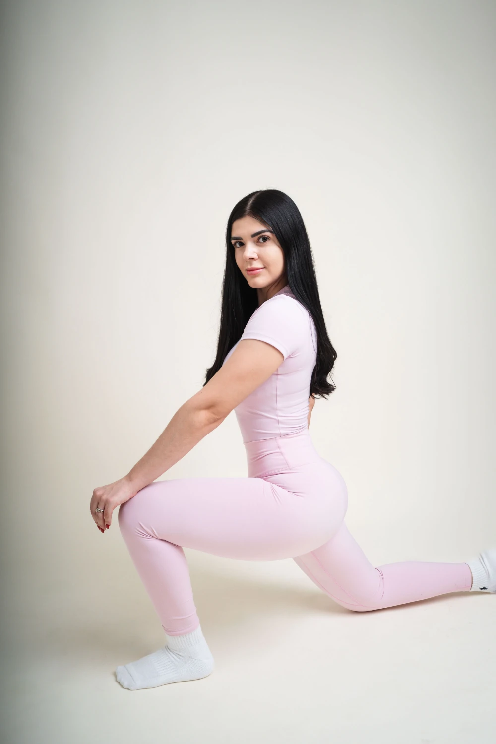 Alumna en desplante bajo, con una rodilla apoyada, durante una clase Flow
